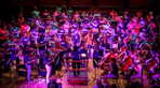 National Orchestra for All performs at CBSO Centre in Birmingham as a NOFA member conducts the ensemble.png
