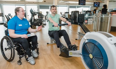 An instructor supporting a customer in the gym_credit Activity Alliance