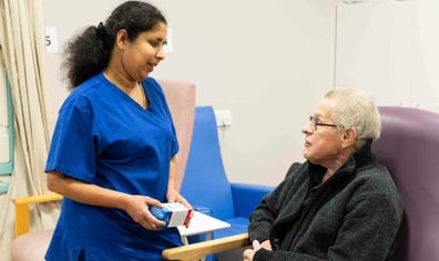 Nurse-talking-with-patient-in-discharge-lounge-aspect-ratio-16-9