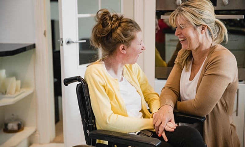 Young adult in wheelchair with carer